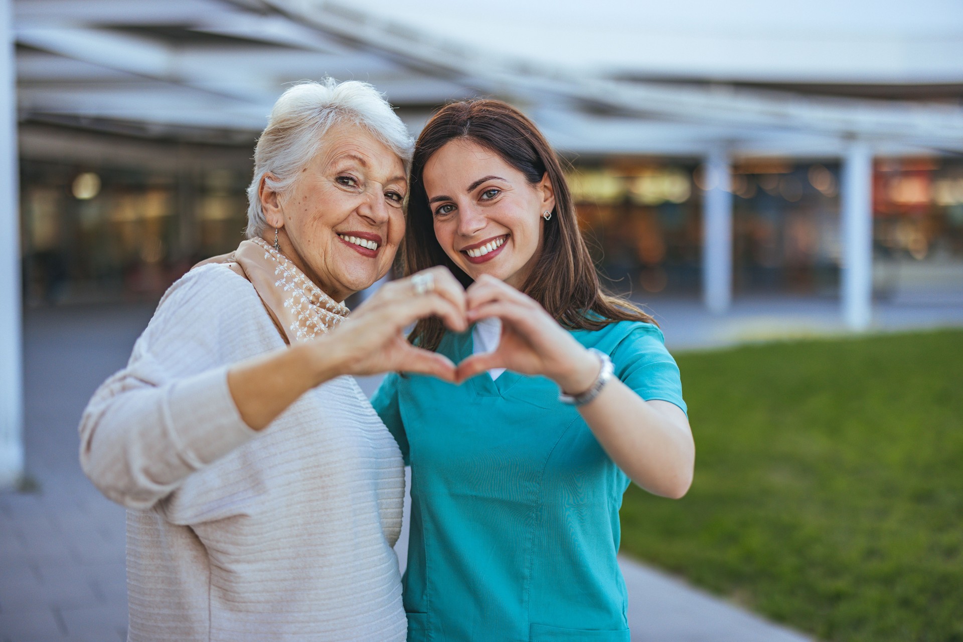 Senior Woman and Caregiver Forming Heart Shape Outdoors Senior Woman and Caregiver Forming Heart Shape Outdoors
